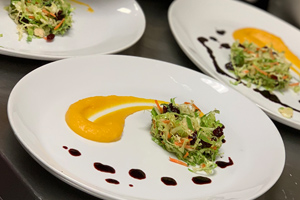 three plates with greens and yellow sauce