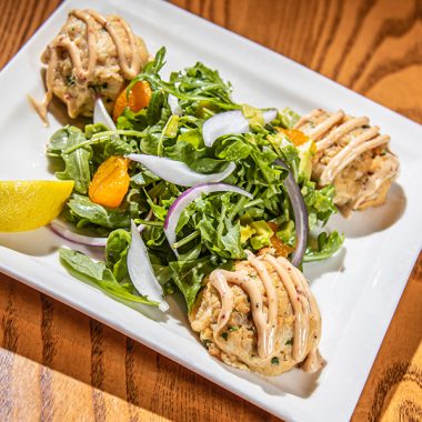 salad and crab cakes on white plate