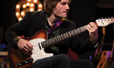 man playing Michael Kelly electric guitar