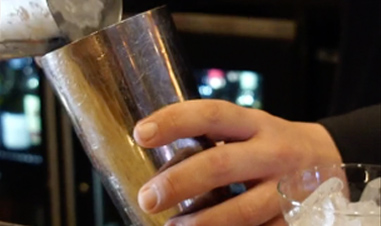 closeup of man's hands making iced drink