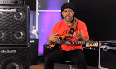 seated musician holding electric guitar