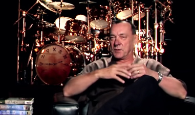 man in front of large drum set