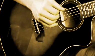 hand playing acoustic guitar