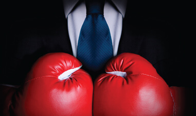partial view of businessman wearing boxing gloves
